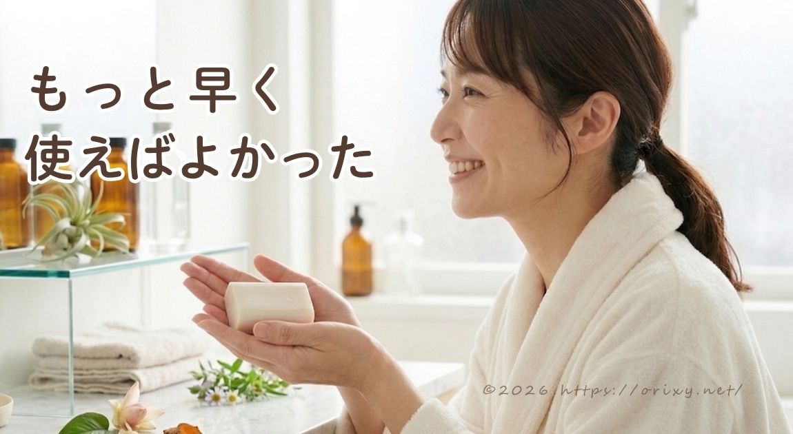 バスローブを着た女性がバスルームでジャムウ石鹸を手に持っているイメージ。